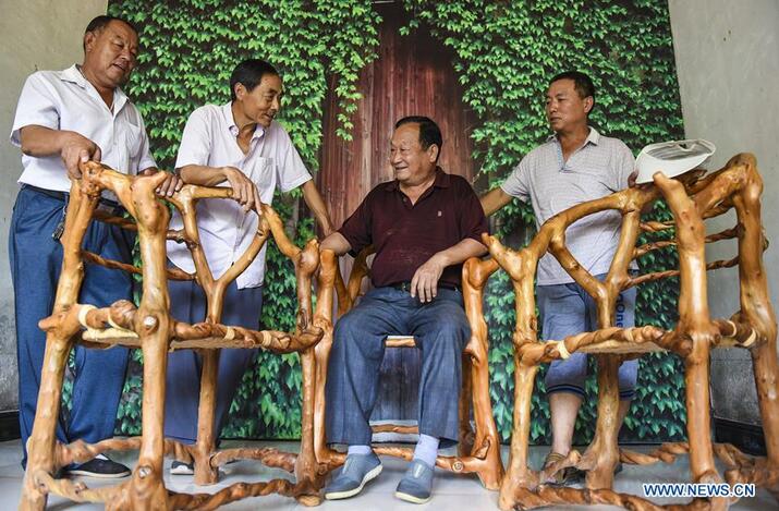 Shang Chunlin (2nd L) presents "ecological furniture" to customers